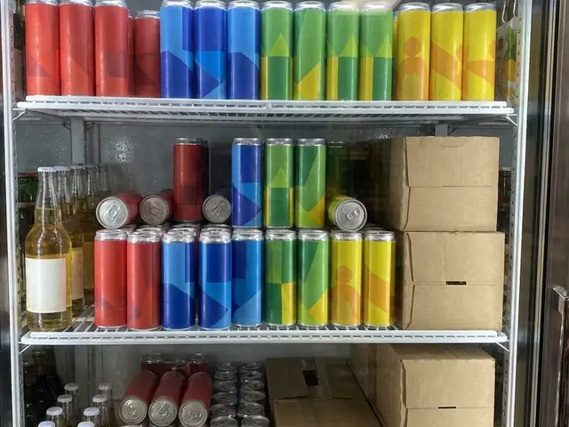 Cooler stocked with cold cans of coolers and seltzers and bottles of cider